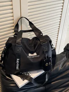 Schwarze Reisetasche für Damen, wasserdichte Sport- und Fitnesstasche mit Katzenanhänger.