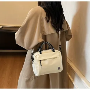 Dettaglio della borsa a tracolla bianco crema con manico intrecciato, stile quotidiano chic