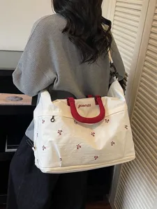 Large capacity expandable travel duffel bag with cute red bow embroidery and comfortable handles.