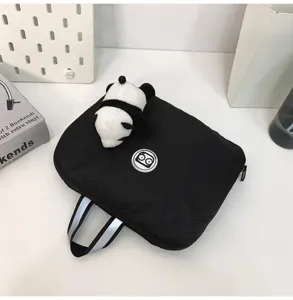 Detailed view of a black portable storage bag with reflective handle and cute panda plush toy.