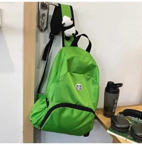 Detail view of lightweight waterproof green casual backpack with cute panda pendant design.