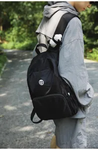 Outdoor black backpack detail showing durable fabric, comfortable straps, and practical pocket.