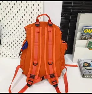 Grand sac a dos de camping orange avec plusieurs sangles et poches pour voyage en plein air.