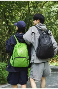 Outdoor travel backpack detail showing shoulder straps and waterproof fabric in a park.