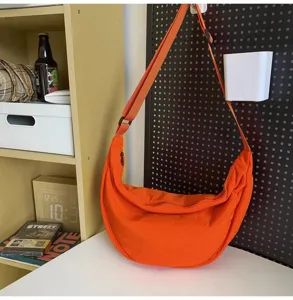 Large capacity orange crossbody bag, casual crescent dumpling shoulder bag for daily use.