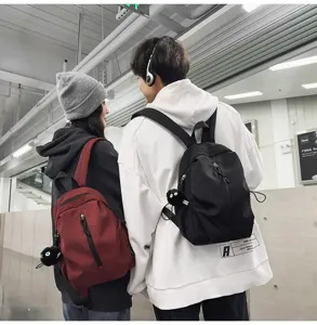 Casual minimalist daily backpack with front zipper and cute plush pendant in detail view.