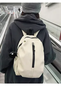 Casual lightweight minimalist backpack with cute soot sprite plush charm for daily commuting travel