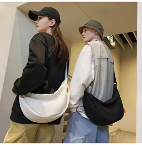 Detail view of the casual canvas crossbody bag worn by models, showcasing large capacity and style.