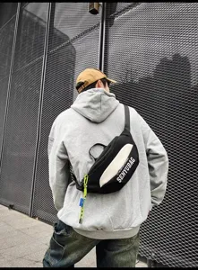 Detail view of a black and white streetwear chest bag, featuring adjustable strap and print.
