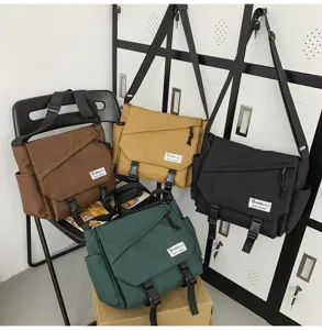 Dettaglio della borsa a tracolla in tela da lavoro in vari colori e grande capienza.