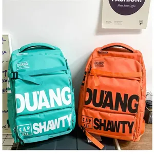 Grand sac à dos de style utilitaire pour voyage et école avec lettres audacieuses et couleurs vives.