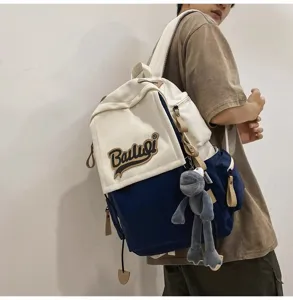 Casual colorblock canvas backpack for students, large capacity travel school bag with doll pendant.