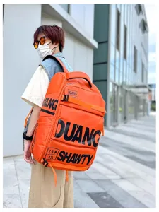 Vue détaillée du sac à dos orange streetwear présentant des lettrages audacieux et de l'espace.