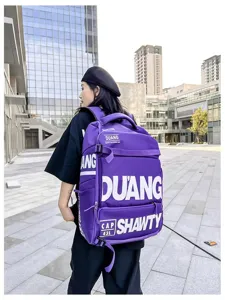 Vue détaillée d'un sac à dos streetwear violet porté à l'extérieur sur une place moderne.