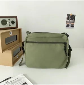 Japanese solid color utility canvas messenger bag detail shot, minimalist casual shoulder bag.