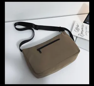 Casual kaki canvas schoudertas met zwarte verstelbare riem en handig ritssluiting detail.