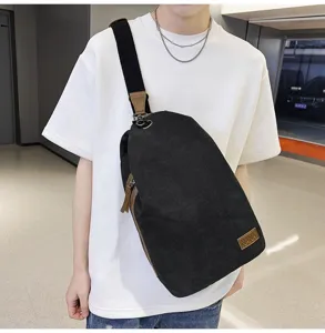 Vue détaillée d'un sac bandoulière en toile noire décontracté porté sur la poitrine, look.