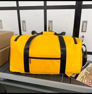 Yellow sports duffel bag detail showing durable black handles, front zipper pocket, and large view.