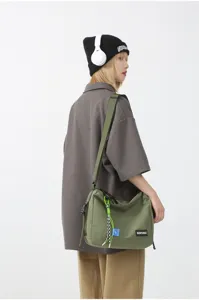 Japanese casual canvas crossbody bag for women and men, solid color workwear style messenger bag.