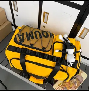 Detail shot of large yellow travel duffel bag with black mesh pocket and handles for gym sports.