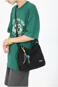 Detail view of Japanese style canvas crossbody messenger bag for men and women, casual black design.