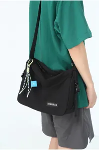 Detail view of the black canvas crossbody messenger bag showcasing workwear style and black strap.