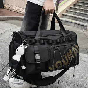 Detailed view of large capacity black travel gym duffel bag with handy hanging plush toy.
