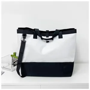 Detailansicht der schwarz-weißen Reisetasche mit stabilen Griffen und geräumigem Fach.