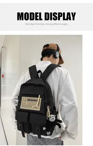 Detailaufnahme eines schwarzen Rucksacks mit mehreren Taschen und einem süßen Affen.