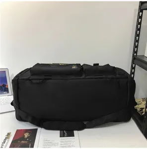 Detailansicht der großen schwarzen Reise-Tasche mit mehreren Taschen und strapazierfähigen Riemen.