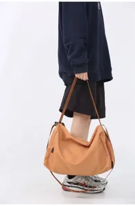 Close-up detail of the large capacity shoulder bag strap and side zipper design for travel.