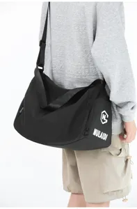 Black gym duffel bag detail showing adjustable shoulder strap and side pocket design.