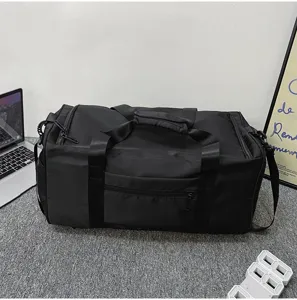 Vue détaillée d'un sac de sport noir en situation avec ordinateur portable, bagage.
