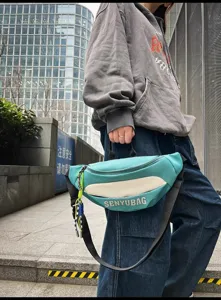 Trendy turquoise chest bag for women and men, stylish casual sling bag for street fashion wear.
