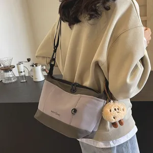 Retro casual canvas messenger bag for women, stylish colorblock shoulder bag with cute plush pendant.