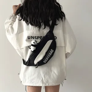 Black and white casual chest bag worn by model, trendy sling bag with cute panda pendant.