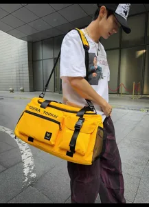 Detail van grote reistas duffel, met duurzame gele stof en diverse handige buitenzakken.