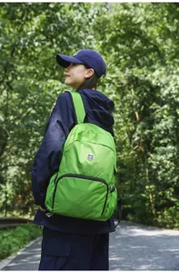 Lightweight outdoor travel backpack detail shot showing green nylon fabric and comfortable fit.