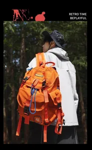 Détail de sac à dos orange de camping en plein air avec sangles fonctionnelles et tissu.