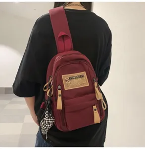 Canvas sling backpack for men and women, casual chest bag with multiple pockets and trendy label.