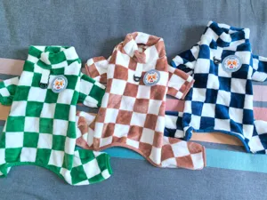 Detail shot of fleece pet clothes, checkered design, four-legged dog apparel for winter warmth.