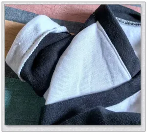 Gros plan sur le tissu de vêtement pour animaux avec coutures noir et blanc et polaire.