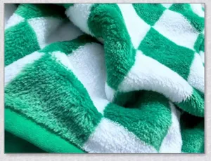 Close-up detail shot of green and white checkerboard plush fabric showing soft fleece texture.