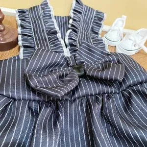 Primo piano dettagliato di un vestito a righe per animali domestici con volant e fiocco.