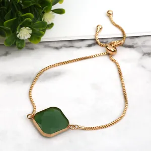 Detailed view of the elegant gold slider bracelet featuring a square green crystal pendant.