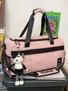 Pink large capacity travel duffel bag with black straps and plush pendant for gym sports.
