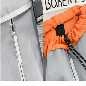 Grey orange backpack detail view, casual daypack with drawstring and zipper, durable travel bag.