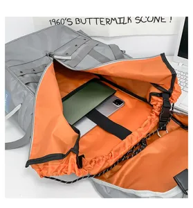 Detailed view of large capacity gray backpack with vibrant orange lining and multi compartments.