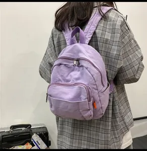 Casual canvas backpack detail showing retro solid color design, front pocket and zipper.