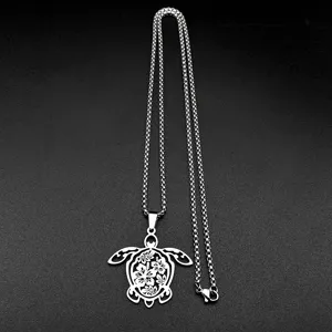 Primer plano detallado del collar con colgante de tortuga plateada y diseño floral.